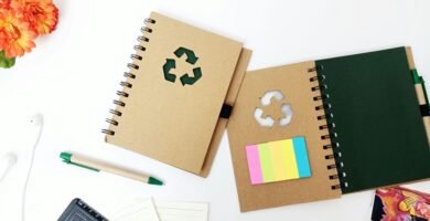 Creative flat lay of eco-friendly notebooks and stationery on a minimal white background.