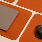 Stylish desktop featuring a laptop and mouse on leather pads, showcasing modern work essentials.
