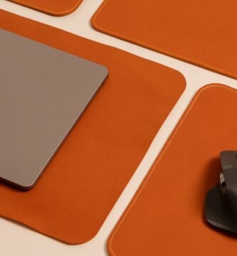 Stylish desktop featuring a laptop and mouse on leather pads, showcasing modern work essentials.
