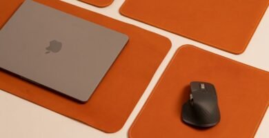 Stylish desktop featuring a laptop and mouse on leather pads, showcasing modern work essentials.