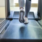 Close-up shot of a person exercising on a treadmill, showcasing fitness and health focus.